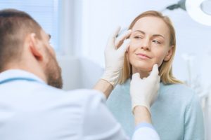 Woman having her face examined by a doctor