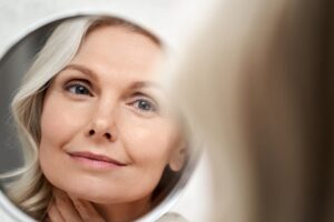 middle age woman with nice skin looking in the mirror