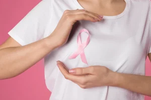 Woman holding a pink ribbon over her chest