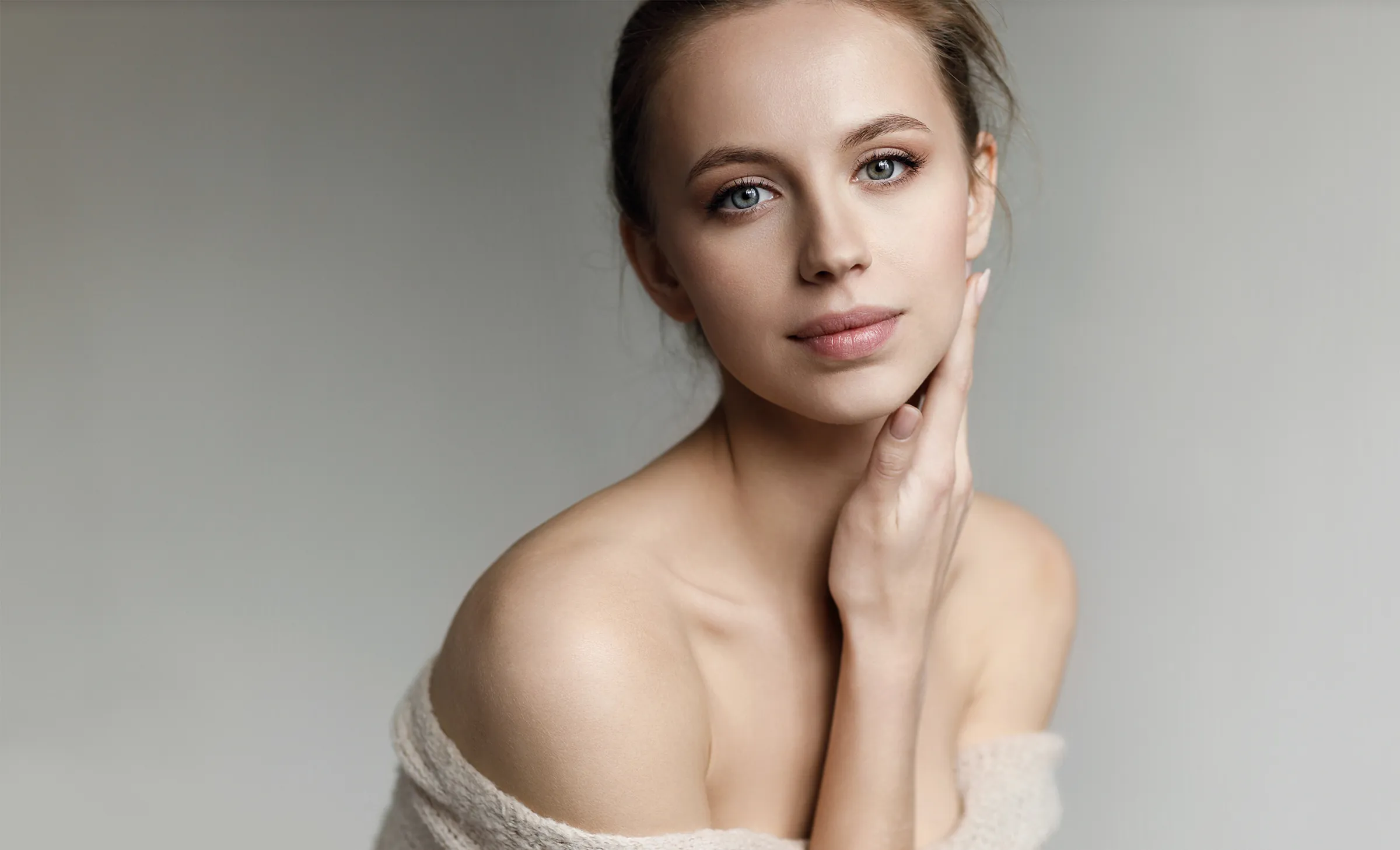 woman with flawless skin touching her face