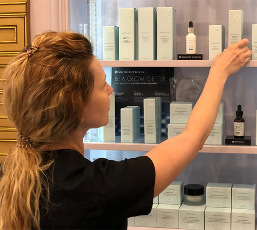 team member choosing skinceuticals product from the display shelf