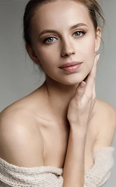 young woman with flawless skin touching her face