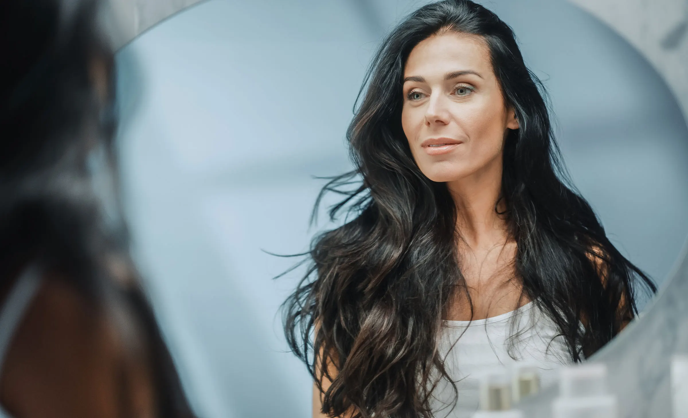 Beautiful Caucasian Middle Aged Woman Looks into Bathroom Mirror
