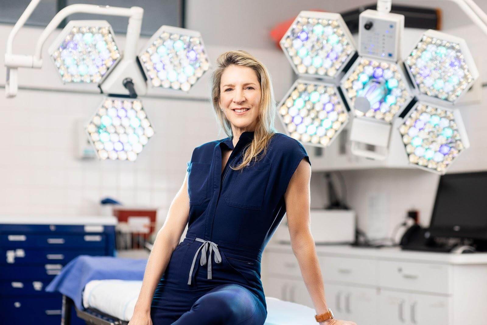 Dr. Lisa Cassileth in operating room with surgical lights, prepared to perform body contouring procedures after weight loss