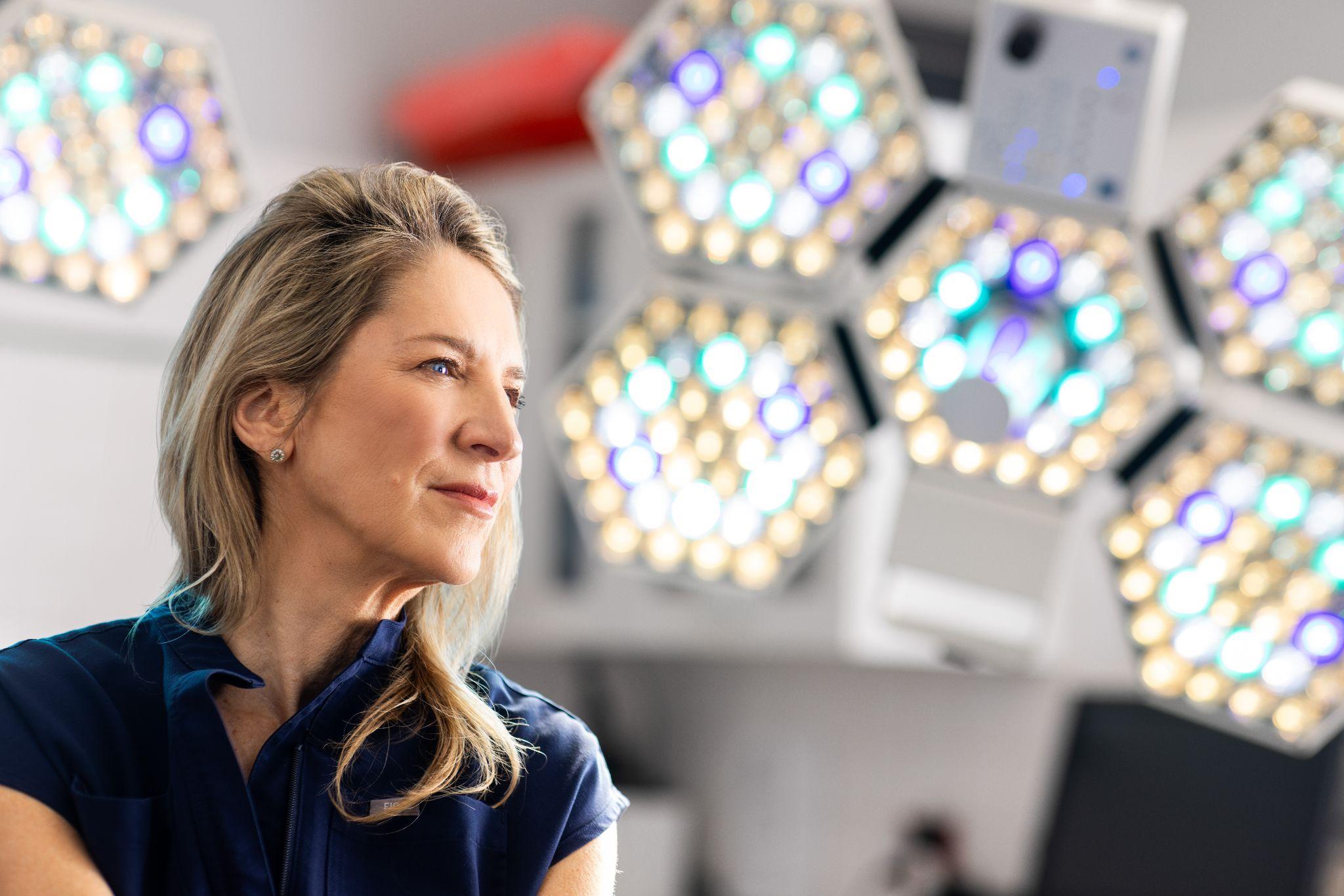 Surgeon in the operating room preparing for breast implant replacement procedure